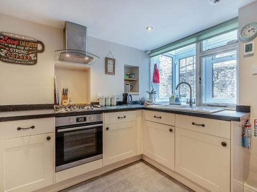 a kitchen with white cabinets and a sink and a window at Four Seasons in Pickering