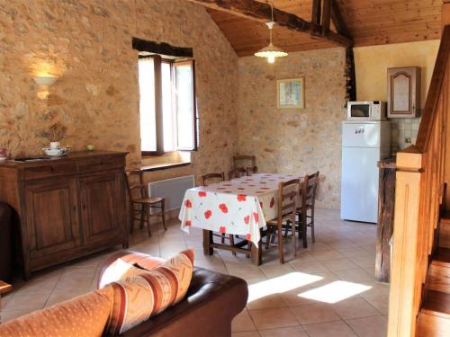 une cuisine et une salle à manger avec une table et un réfrigérateur dans l'établissement Maison de campagne avec 3 chambres, wifi, terrasse, proche sites touristiques, animaux acceptés - FR-1-616-138, à Azerat