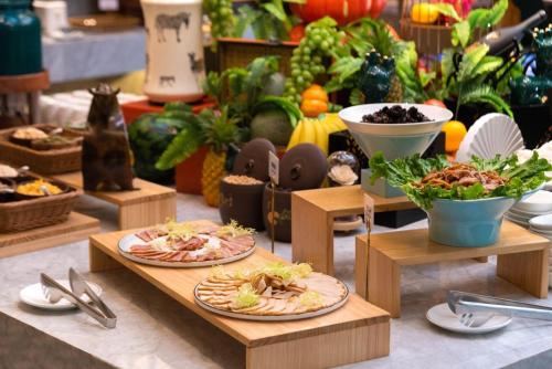two plates of food on wooden tables with vegetables at Atour X Hotel Shenzhen Bao'an Airport West Bay Mangrove in Bao'an