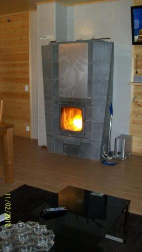 a fireplace in a living room with a fire in it at Lake Cottage Jänisvaara in Kolinkylä