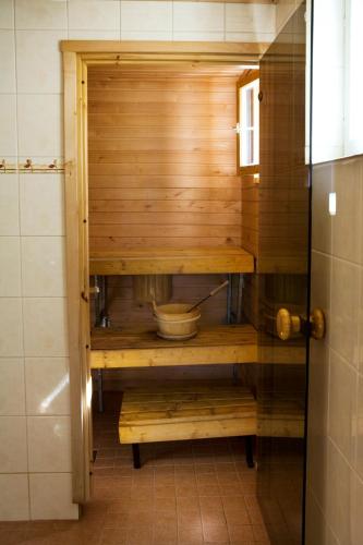a bathroom with a wooden cabinet with a bowl at Lake Cottage Jänisvaara in Kolinkylä