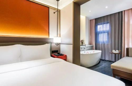a hotel room with a bed and a bath tub at Manxin Hotel - Beijing Zhongguancun University of Technology in Beijing