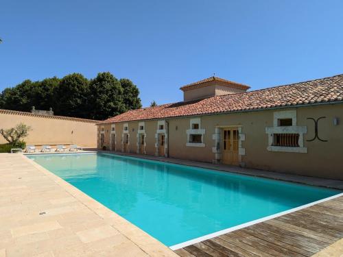 une piscine devant un immeuble dans l'établissement Charmante Maison de Campagne avec Piscine Chauffée en Charente - FR-1-653-278, à Abzac