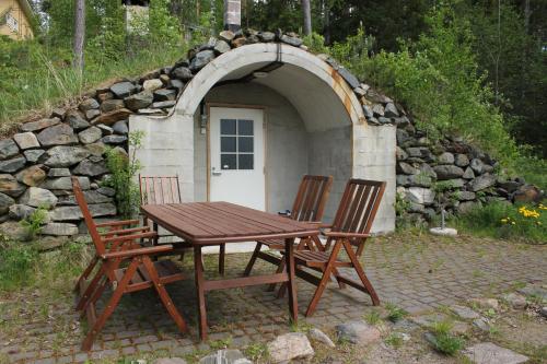 a wooden table and chairs in front of a stone building at Lake Cottage Jänisvaara in Kolinkylä
