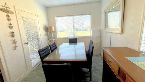 a table and chairs in a room with a table and windows at The Blue Groper in Minnie Water