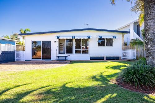 a white house with a lawn in front of it at Family Tides in Kinka