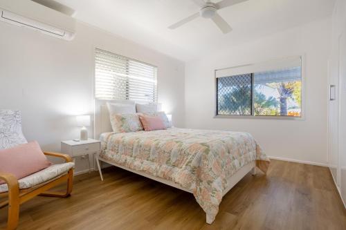 a bedroom with a bed and a chair and a window at Family Tides in Kinka