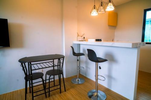 a kitchen with two bar stools and a counter at The Grounds Hotel in San Jose del Monte