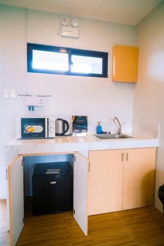 a kitchen with a counter with a microwave and a sink at The Grounds Hotel in San Jose del Monte