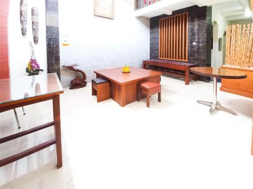 a living room with a table and a bench at Wisma Trubus Syariah RedPartner Near RSUD Koesma Tuban in Tuban