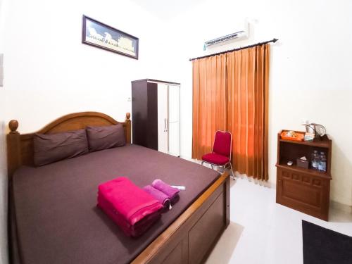 a bedroom with a large bed with pink towels on it at Wisma Trubus Syariah RedPartner Near RSUD Koesma Tuban in Tuban
