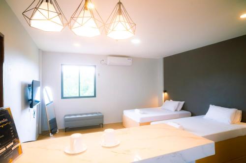 a hotel room with two beds and a tv at The Grounds Hotel in San Jose del Monte