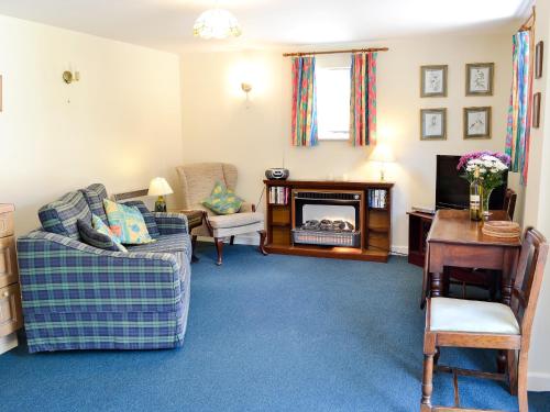 a living room with a couch and a fireplace at Pig Sty Cottage - E1867 in Powerstock
