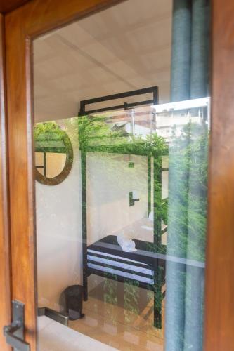a reflection of a window with a bench in it at Mich's Surf Villa & Hostel in Weligama