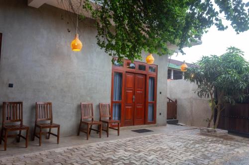 a group of chairs sitting in front of a building at Mich's Surf Villa & Hostel in Weligama