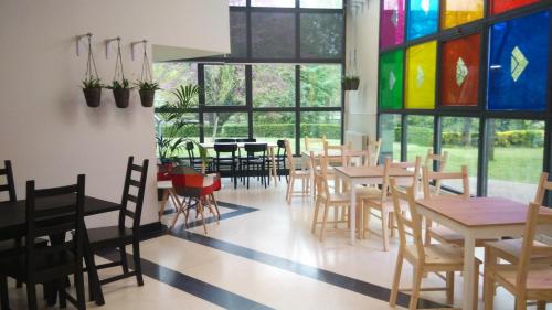 a restaurant with tables and chairs and colorful stained glass windows at Errota Ostatua in Durango