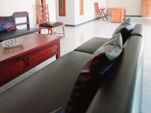 a living room with a couch and a table at RedDoorz near BNS 3 Kota Wisata Batu in Malang
