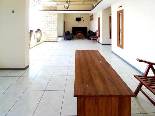 a living room with a wooden table on a tile floor at RedDoorz near BNS 3 Kota Wisata Batu in Malang