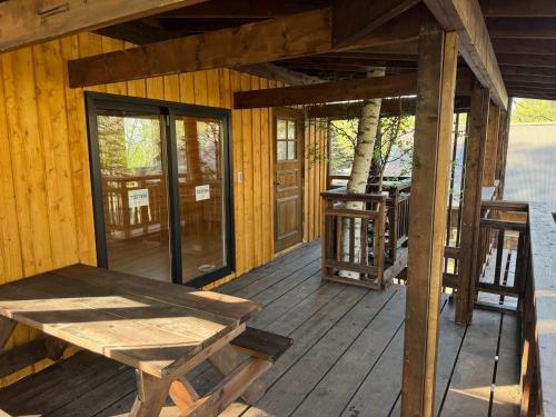 un portico in legno di una cabina con una panca in legno di Playhouse Conifer - Vacation STAY 35448v a Mikage