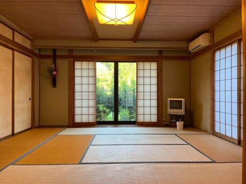 an empty room with doors and windows and a television at Fukuzawa Ryokan - Vacation STAY 39918v in Sakai