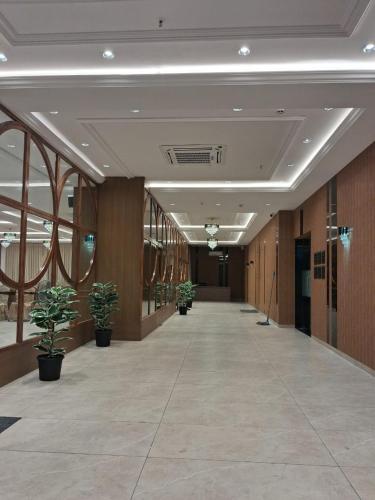 an empty hallway with potted plants in a building at Hotel Royal Bloom in Surat