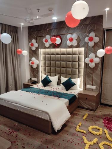 a bedroom with a large bed with red and white decorations at Hotel Royal Bloom in Surat