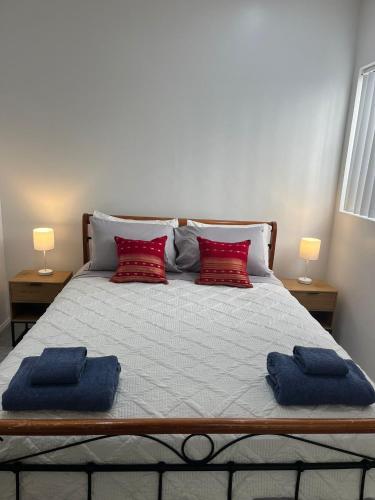 a bed with two pillows on it with two lamps at CozyHomes Woolloongabba B&B in Brisbane