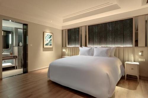 a large white bed in a hotel room at La Siesta Premium Lakeside in Hanoi