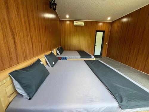 a bedroom with two beds in a boat at Du Già Ngọc Homestay in Yên Minh