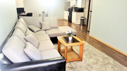 a living room with a white couch and a table at Cozy 2-Bedroom Basement Suite Retreat Calgary in Calgary