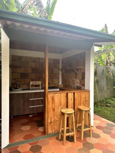 an outdoor kitchen with two stools and a counter at Glamping Cabaña Familiar Campestre 103 in Choachí