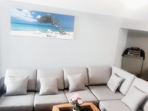 a living room with a couch with a picture of the ocean at Cozy 2-Bedroom Basement Suite Retreat Calgary in Calgary