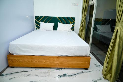 a bedroom with a bed with white sheets and a mirror at Bellajooz Lake Resort in Takwa Budrukh