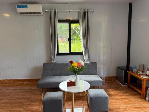 a living room with a couch and a table with flowers at SODANY RESORT Kohrong in Koh Rong