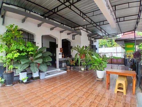 a room with a table and a bunch of plants at RedDoorz at Ndalem Eyyang Syariah Stasiun Klaten in Klaten