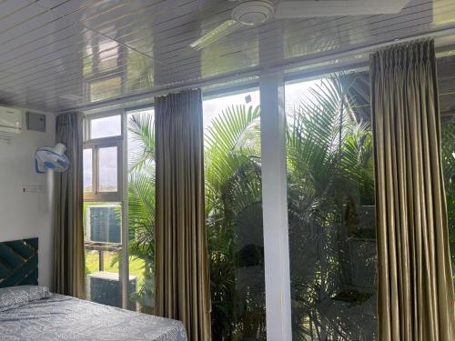 a bedroom with a window with curtains and a bed at Bellajooz Lake Resort in Takwa Budrukh