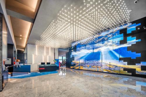 a lobby with a large painting on the wall at Novotel Kunming City Center in Kunming