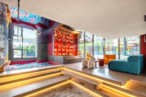 a living room with a blue couch and windows at Novotel Kunming City Center in Kunming