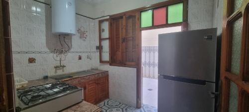 a small kitchen with a refrigerator and a sink at Zagour Houses in Asilah