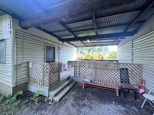 a porch with a bench and a tv on a house at Shinfuji Auto Campsite - Vacation STAY 53262v in Kami-ide