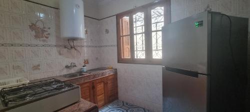 a kitchen with a refrigerator and a sink and a window at Zagour Houses in Asilah