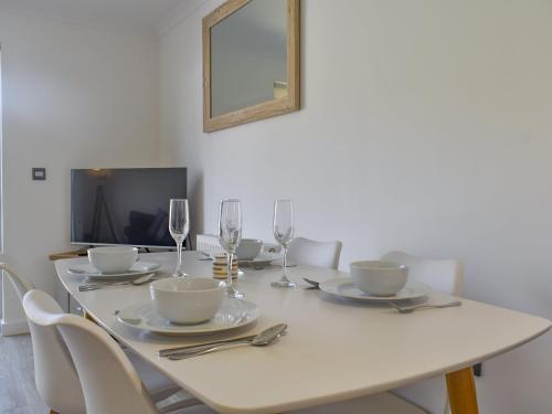 una mesa de comedor blanca con vasos y cubiertos en Coastal Soul - Uk43464, en Sandown