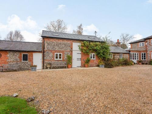 an old brick house with a white garage at The Stables At Wells-In-The-Field Farm in Whitchurch