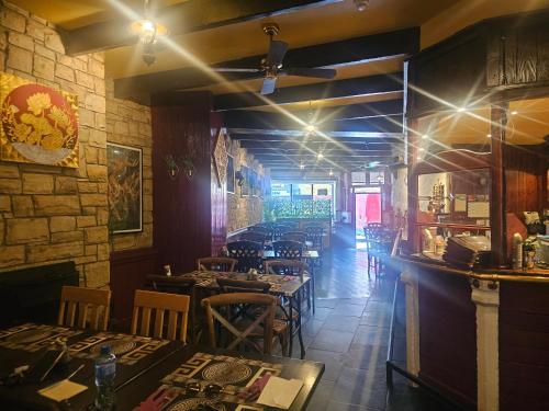 a restaurant with tables and chairs in a room at Listowel Town in Listowel