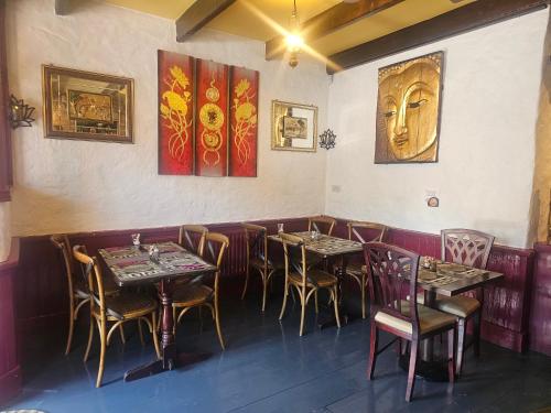 a restaurant with tables and chairs and paintings on the wall at Listowel Town in Listowel