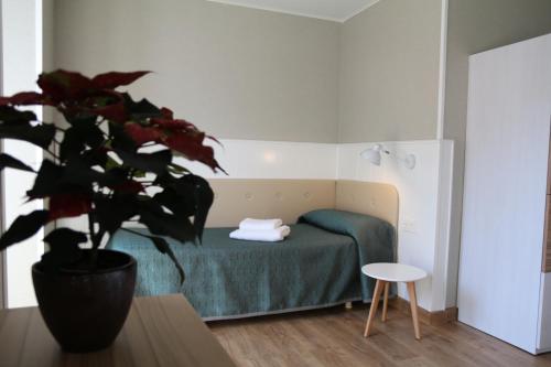 Un dormitorio con una cama verde y una maceta en Errota Ostatua en Durango