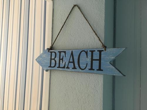 a sign with the word beach hanging on a door at Hotel Kelly in Rimini