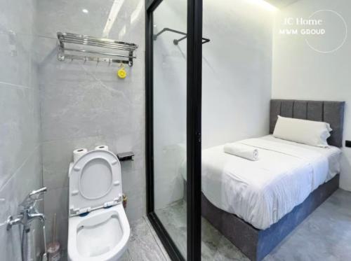 a bathroom with a toilet and a bed in a room at Room l 4min Walks to Pelangi Plaza in Johor Bahru