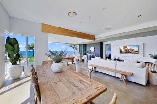a living room with a wooden table and chairs at Riva in Bargara