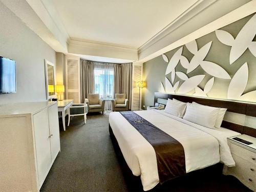 a hotel room with a large bed and a television at The Pearl Kuala Lumpur in Kuala Lumpur